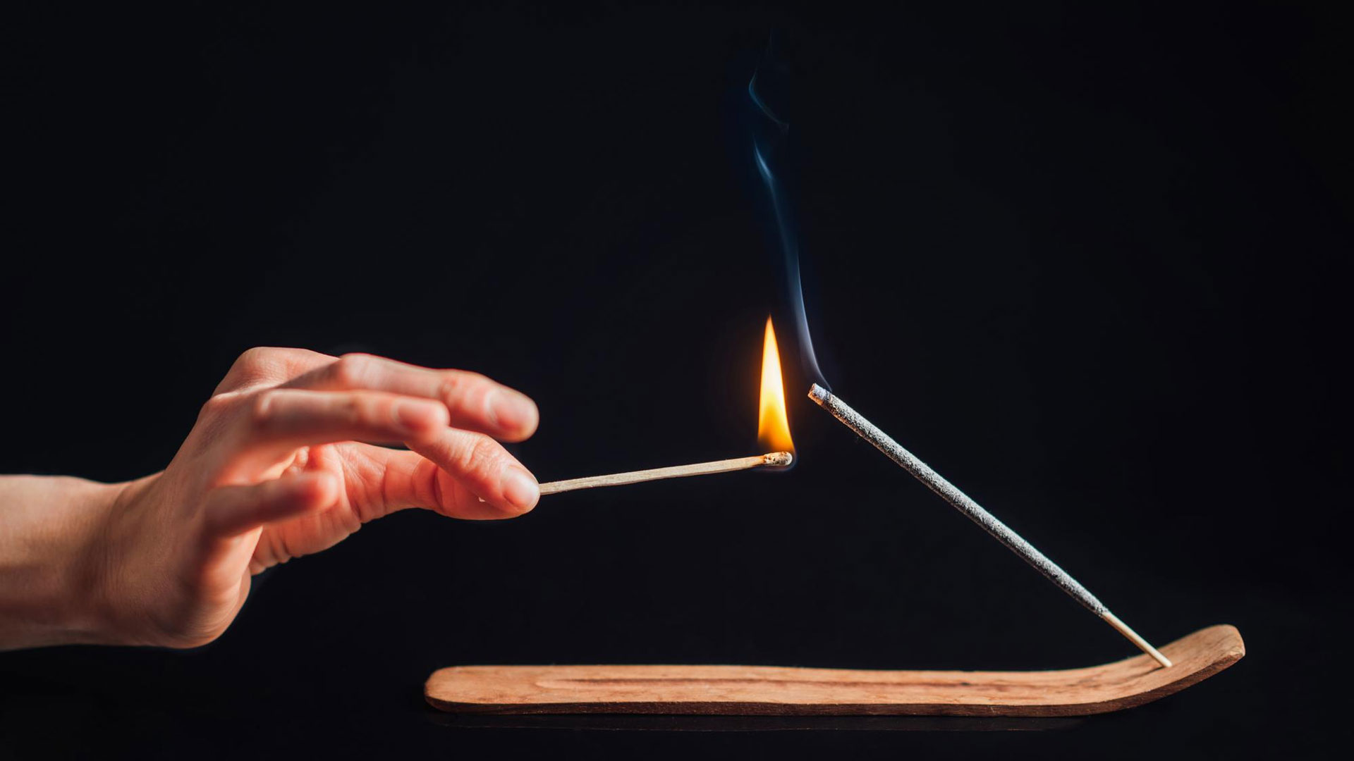 lighting incense stick with burning match stick