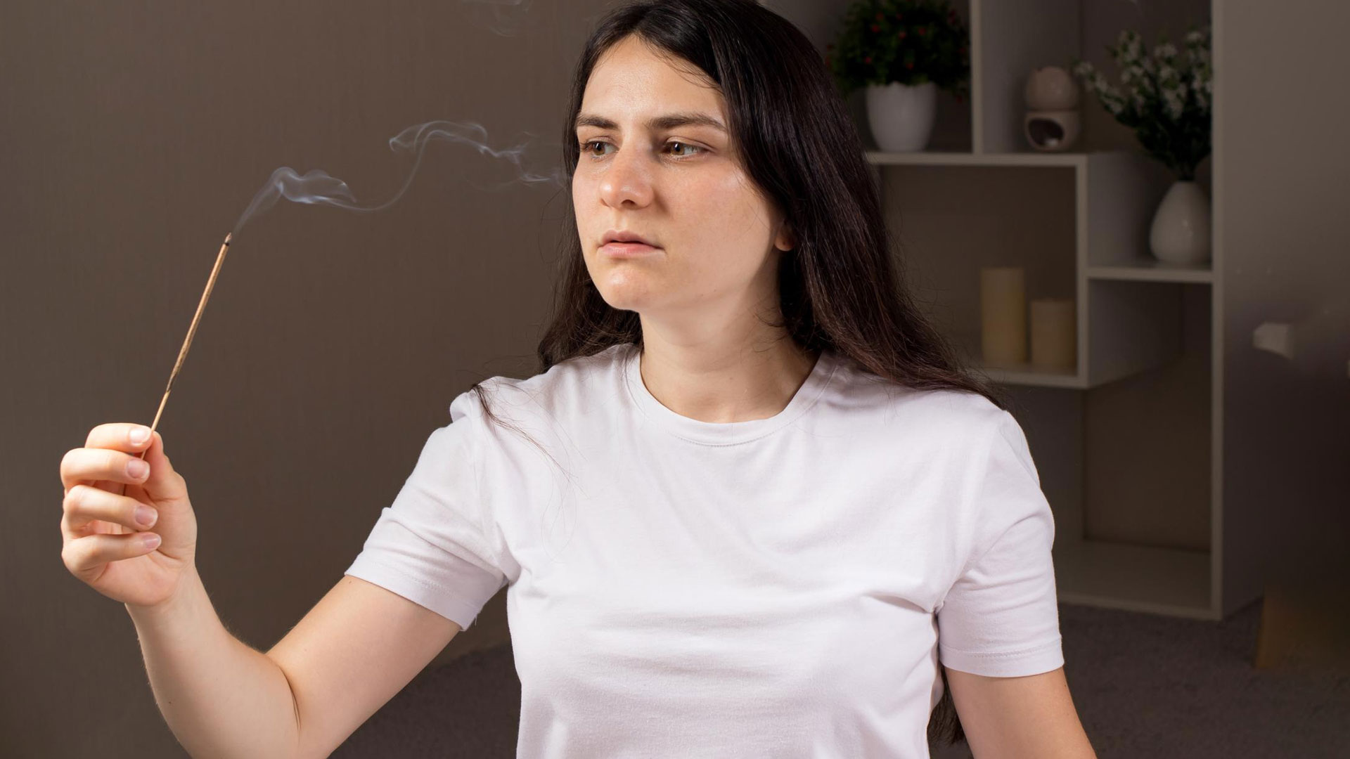 woman smelling from incense stick