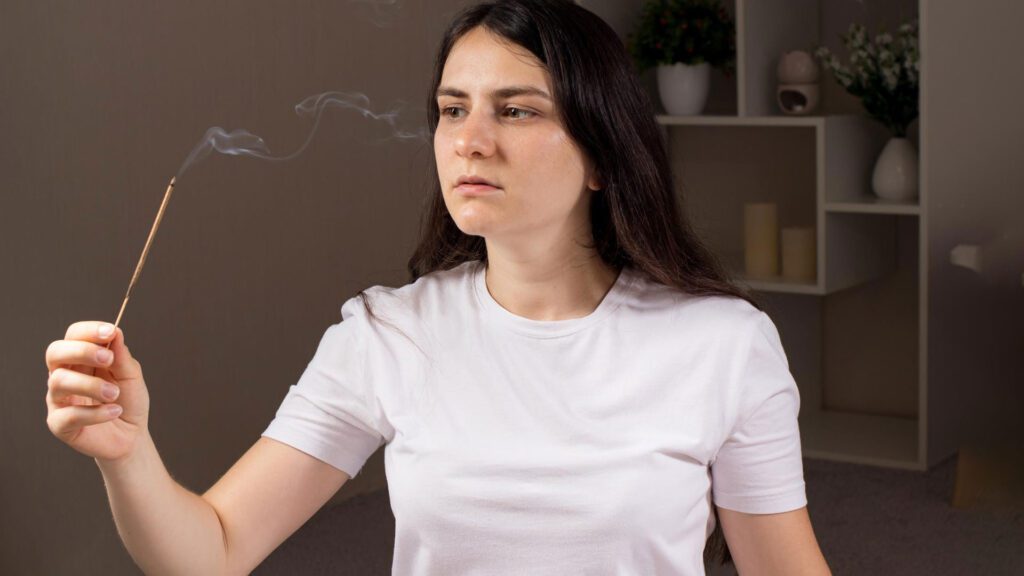 woman smelling from incense stick