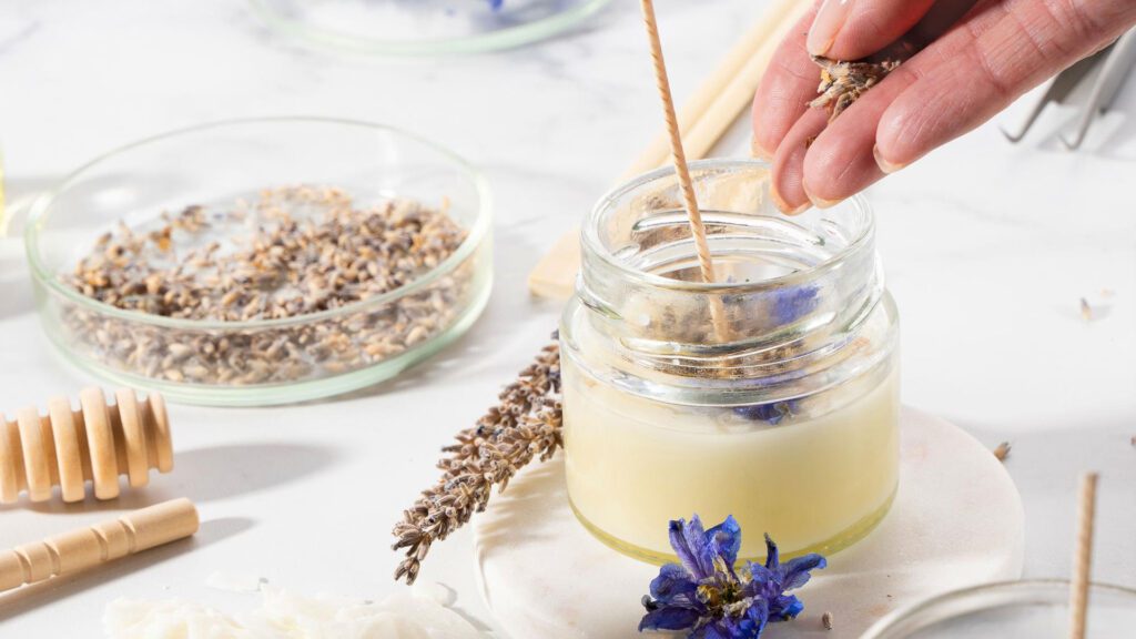 Putting dried herbs in candle