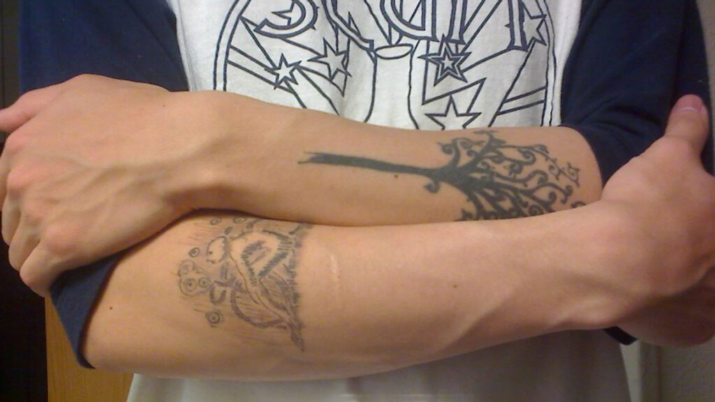 Man with faded tattoos on arm.
Essential oils do not fade tattoos
